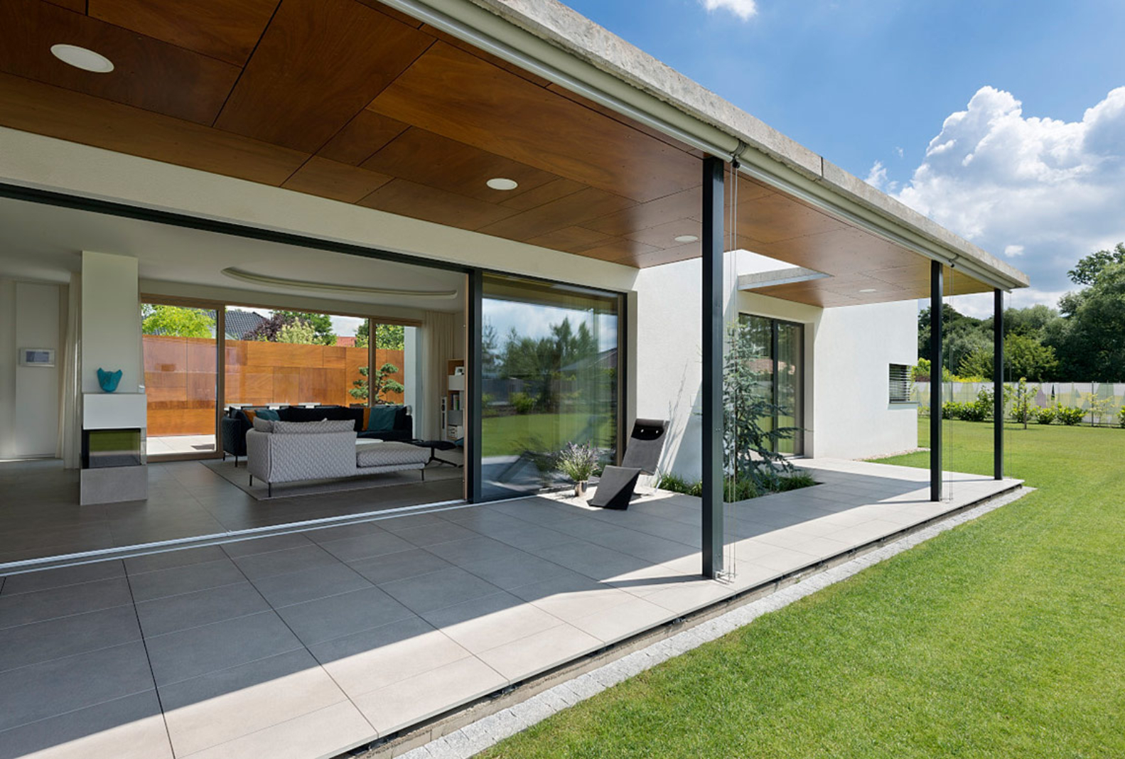 Architektonický návrh a realizace rodinného domu v Pardubicích. terasa podél celého doma s minimalistickým zastřením s prostupem pro růst stromu ing. arch. Pavla Tylichová